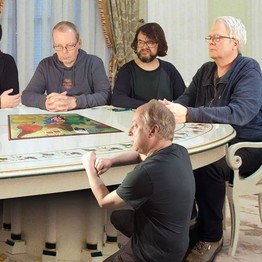 Foto der fünf Brauseboys, die um einen Tisch sitzen