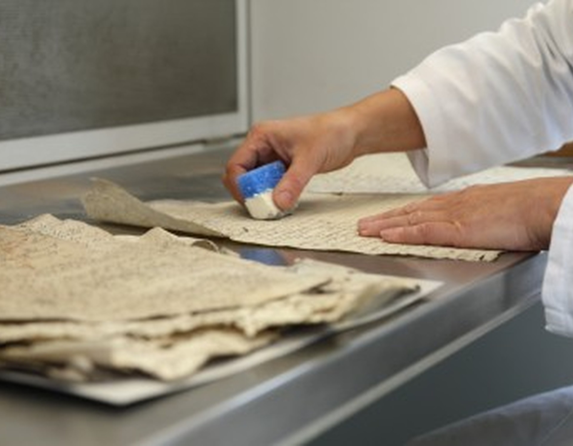 Hände bei der Restauration einer Originalhandschrift
